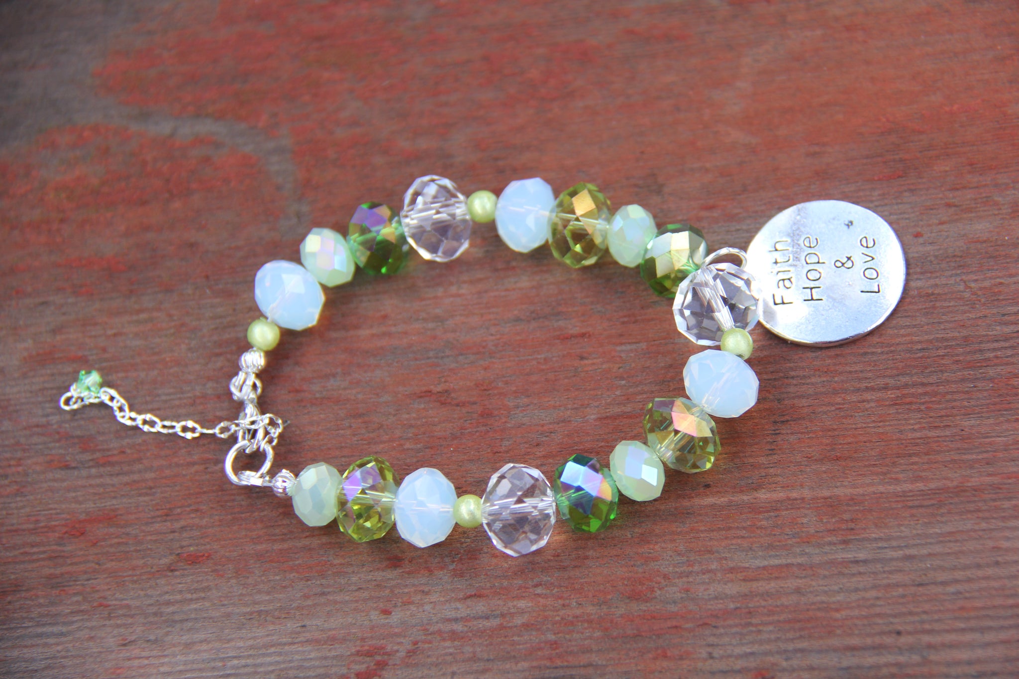 Faith, Hope & Love silver charm on a green glass beads bracelet